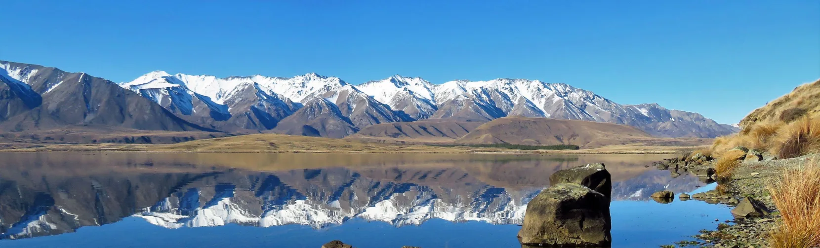 Snow-capped mountains reflecting in Lake Heron, Ashburton Lakes, New Zealand