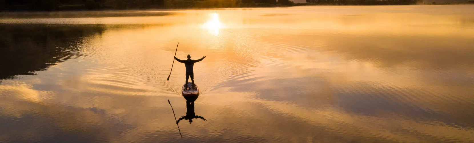 Person paddleboarding on Lake Camp at sunset, Ashburton Lakes, New Zealand