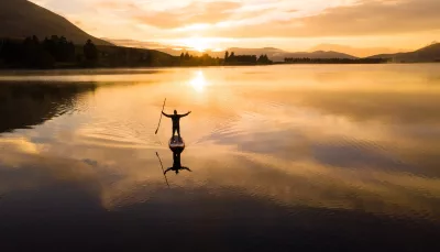 Person paddleboarding on Lake Camp at sunset, Ashburton Lakes, New Zealand