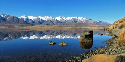 Snow-capped mountains reflecting in Lake Heron, Ashburton Lakes, New Zealand