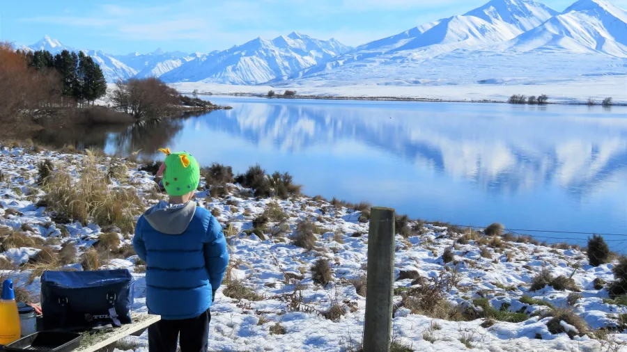 Child enjoying the snowy landscape at Lake Clearwater, Ashburton Lakes, New Zealand