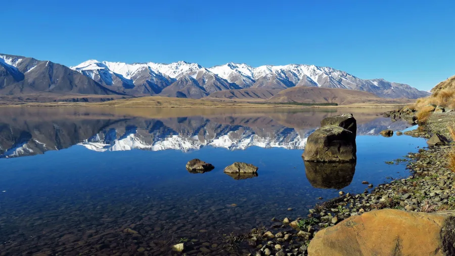 Snow-capped mountains reflecting in Lake Heron, Ashburton Lakes, New Zealand