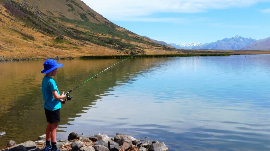Child fishing at Lake Emma in the Ashburton Lakes region, New Zealand
