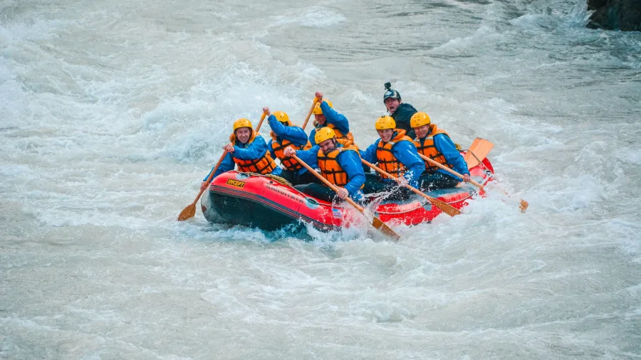 Team of rafters taking on fast-flowing rapids on the Rangitata River