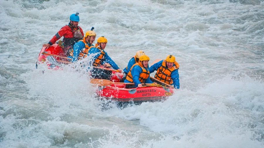 Adventurers white-water rafting through waves on the Rangitata River in Canterbury