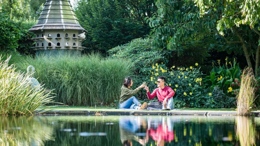 Couple relaxing by the pond at Trotts Community Garden in Ashburton, New Zealand