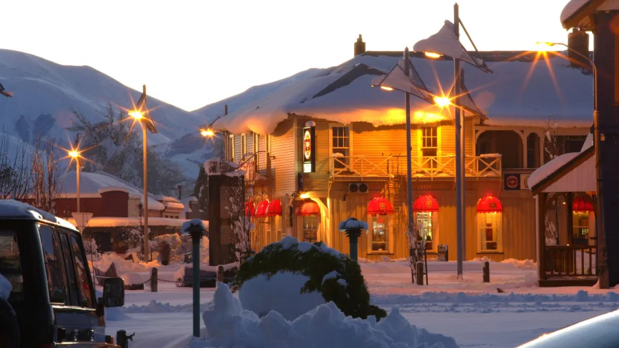 Methven town centre in winter with snow and warmly lit buildings