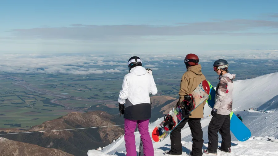 Snowboarders overlooking Canterbury Plains from Mt Hutt Ski Field near Methven