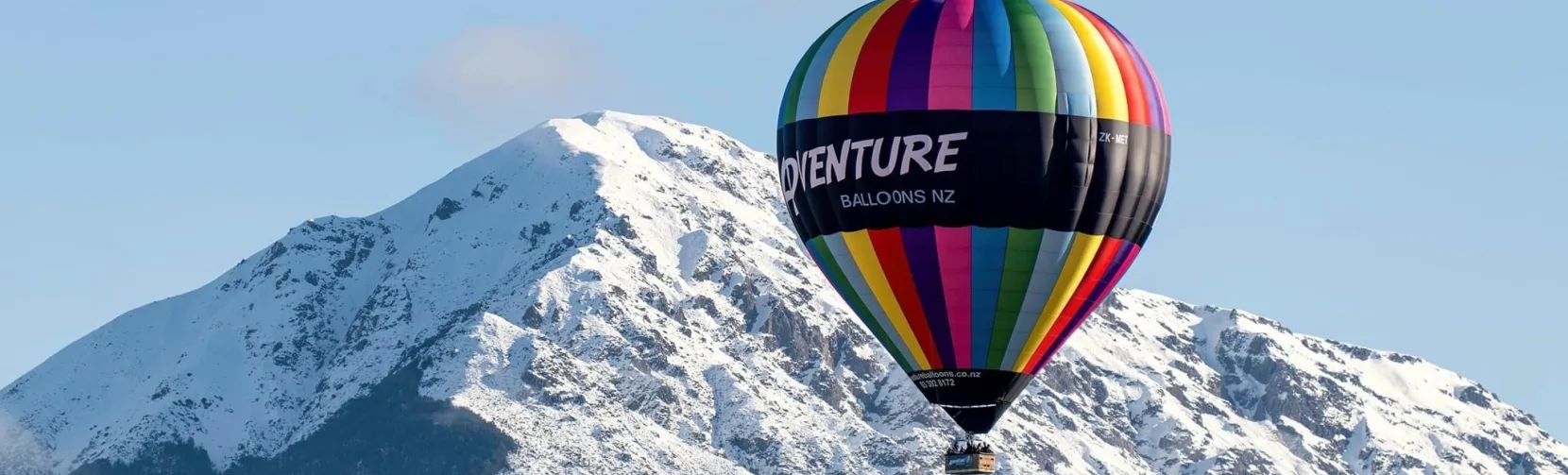Hot air balloon flying over snowy mountains in Methven Canterbury