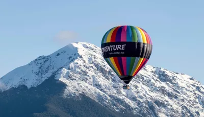 Hot air balloon flying over snowy mountains in Methven Canterbury