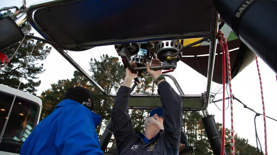 Pilot performing pre-flight burner check before hot air balloon take-off in Methven