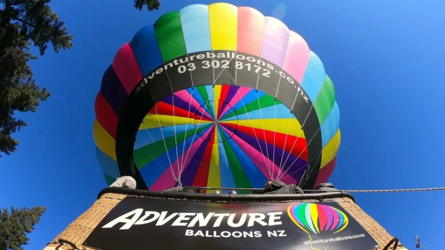 View from below of rainbow hot air balloon in Wanaka
