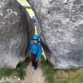 Woman walking through a narrow gap between limestone boulders at Castle Hill, Canterbury