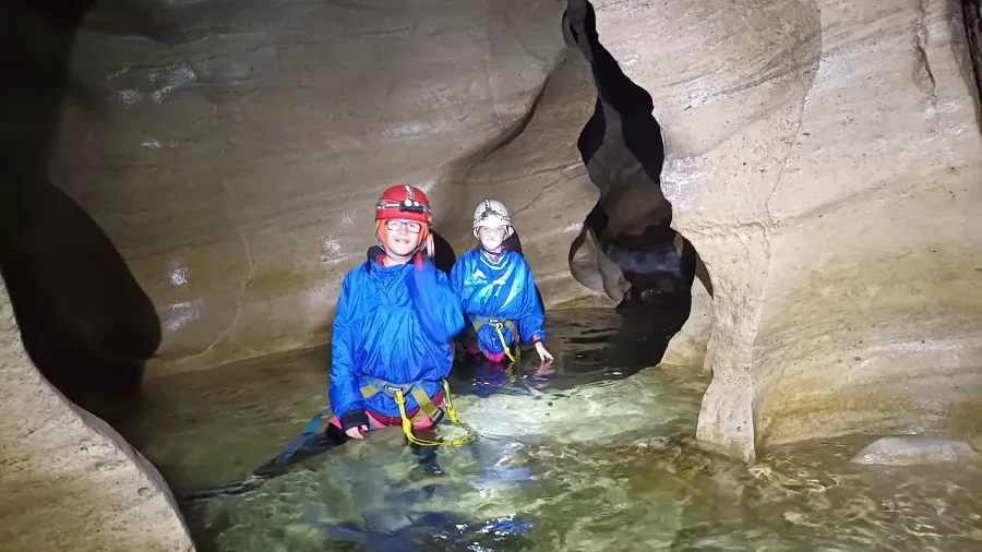 Two children wading through shallow water inside Cave Stream cave system