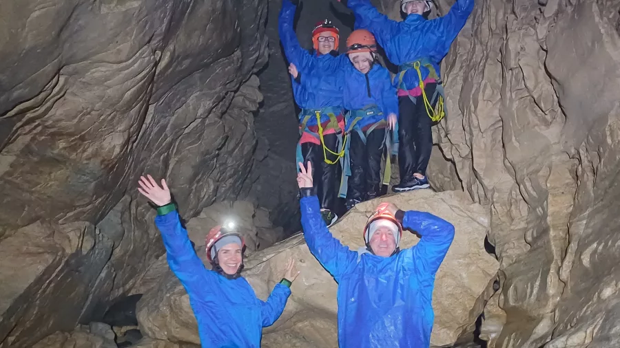 Group of cavers raising arms inside Cave Stream cave