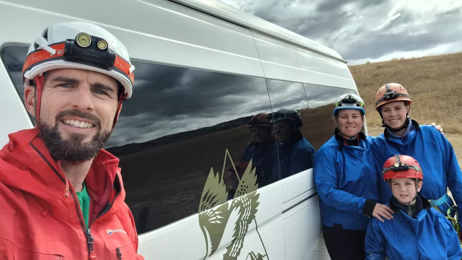 Family posing in front of tour van after Cave Stream adventure in Canterbury