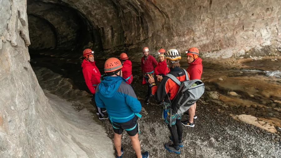 Group of cavers with helmets gathered at the Cave Stream entrance with guide