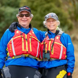 Smiling older couple in kayaking gear during Lyttelton tour