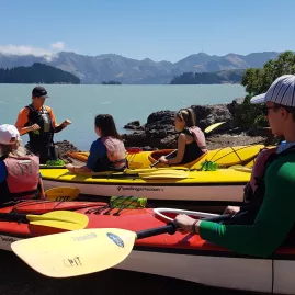 Kayaking group receiving safety briefing beside Lyttelton Harbour
