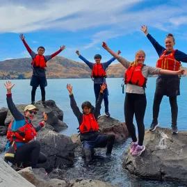 Group of kayakers posing on rocks near Quail Island, Lyttelton Harbour