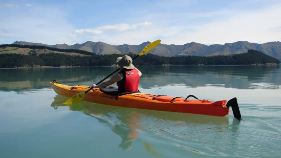 Person kayaking solo on calm turquoise water near Quail Island