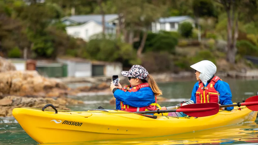 Two people kayaking near Quail Island, one taking a photo