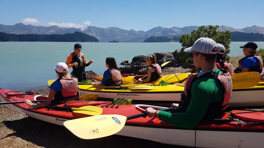 Kayaking group receiving safety briefing beside Lyttelton Harbour
