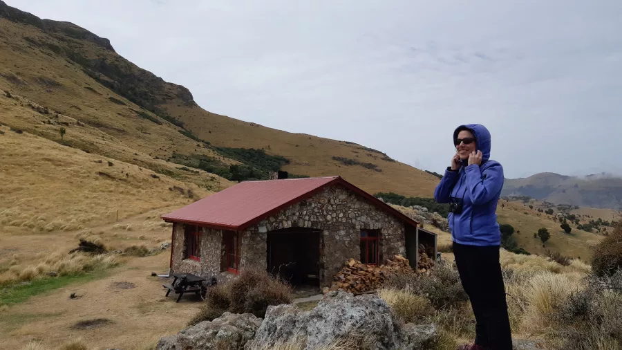 Female hiker standing near Packhorse Hut in Canterbury’s tussock-covered hills