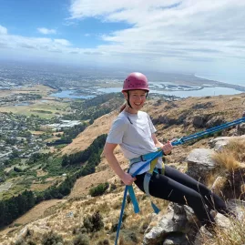 Woman abseiling with panoramic views over Christchurch and the coastline