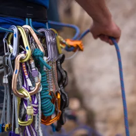 Close-up of a climber’s harness with carabiners, quickdraws and ropes ready for action