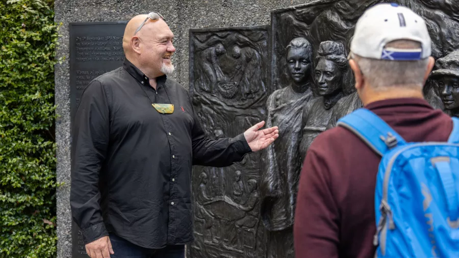 Guide speaking in front of the Kate Sheppard Memorial in Christchurch