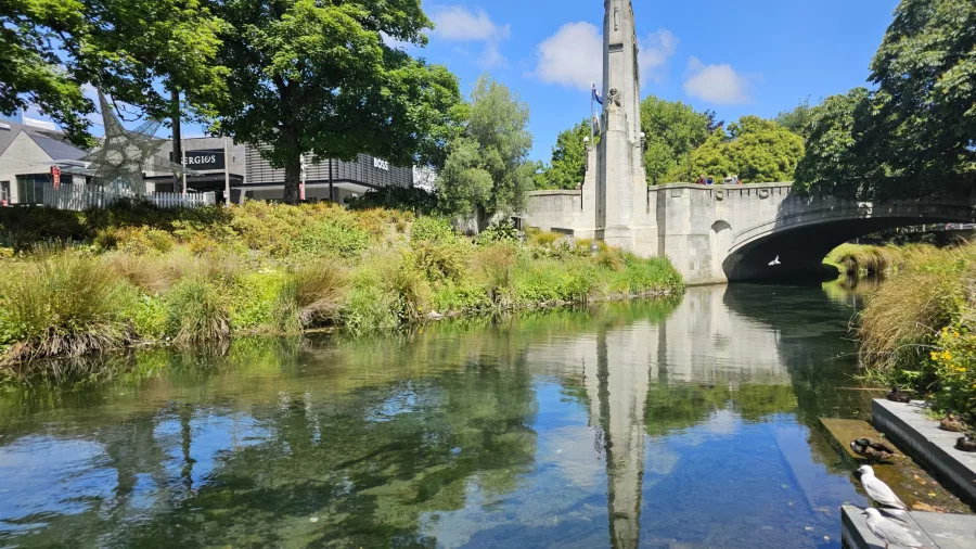 Bridge of Remembrance reflected in the Avon River on a sunny day in central Christchurch