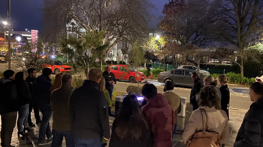 Group of people on an evening guided tour in central Christchurch, stopping to listen to a guide