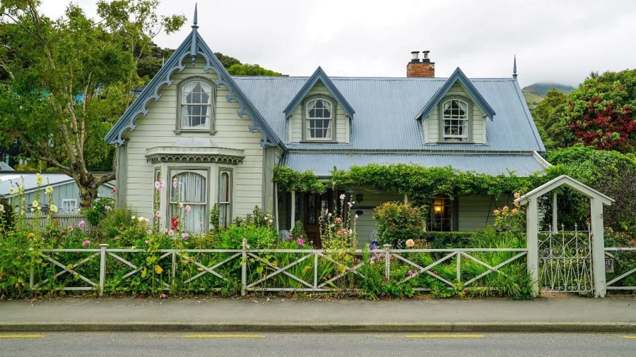 Vintage wooden villa in Akaroa with a flower-filled garden and picket fence