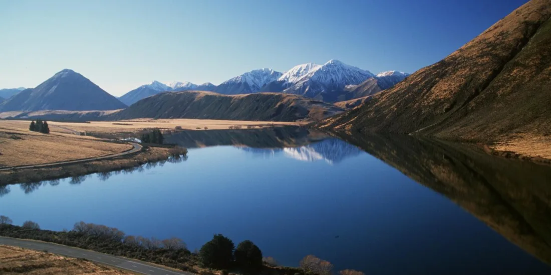 Scenic view of Lake Pearson with mountain reflections near Arthur’s Pass, Canterbury