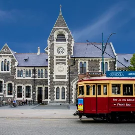 Historic red Christchurch tram outside the Arts Centre building