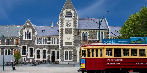 Historic red Christchurch tram outside the Arts Centre building