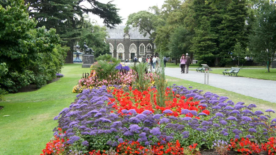 Flower beds in full bloom at Christchurch Botanic Gardens, with the historic Canterbury Museum building in the background.