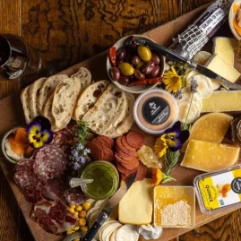 Cheese and charcuterie board with Pegasus Bay wine at a Waipara winery.