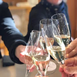 Group clinking glasses of sparkling wine during a tasting in Waipara.