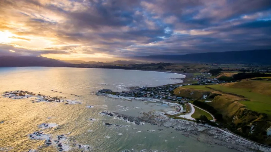 Aerial view of Kaikōura Peninsula and coastline at sunset with dramatic skies