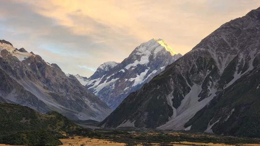 Sunset lighting up Aoraki Mount Cook with golden tones over the surrounding valley