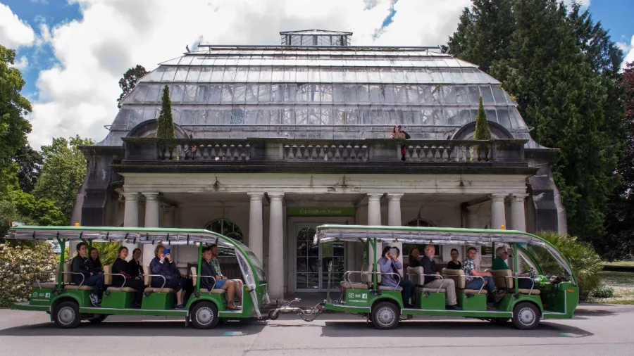 Christchurch Botanic Gardens shuttle parked in front of Cuningham House, the historic glass conservatory.