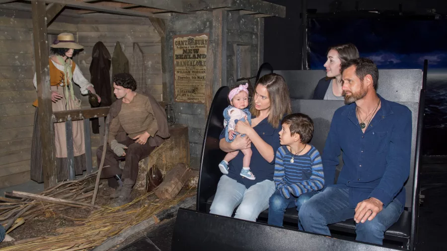 Family enjoying the Time Tunnel ride at Christchurch Gondola, passing historical dioramas
