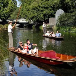 Families punting on the Avon River near Worcester Street Bridge with Hagley Park in the background