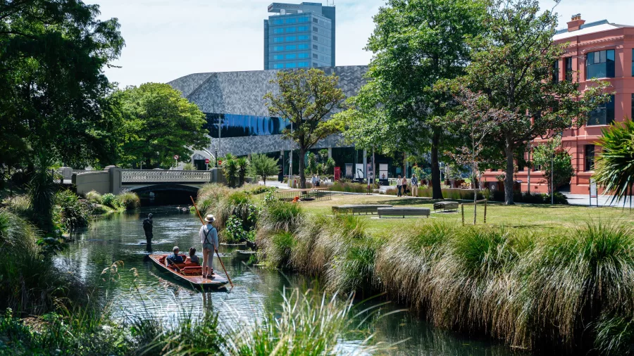 Punting on the Avon River with Te Pae Convention Centre in Christchurch