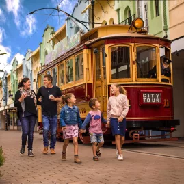 Family walking beside a Christchurch Tram on New Regent Street