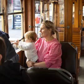 Family enjoying a scenic ride on the Christchurch Tram, looking out the windows.