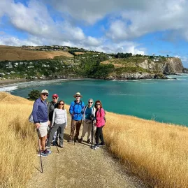 Hiking group on grassy track overlooking Taylors Mistake and the coastline