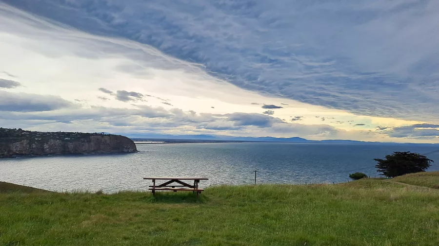 Scenic coastal view from Godley Head with picnic table overlooking Sumner and Taylors Mistake